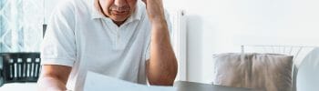 man at desk with his head in his hands