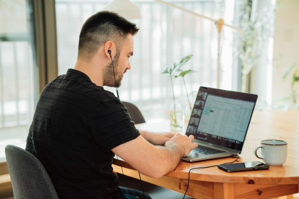 man sitting at a desk using laptop